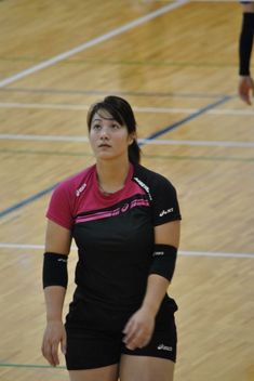 a woman standing on top of a basketball court holding a racquet in her hand