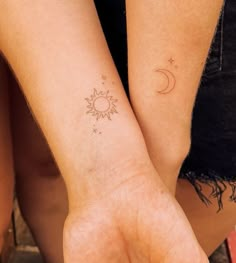 two people with matching tattoos on their arms, one holding the other's hand