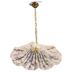 a chandelier hanging from a chain with an open shell design on the bottom