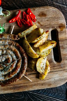 some food is laying out on a cutting board with skewered potatoes and peppers