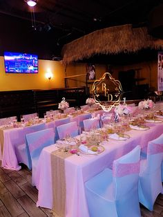 the tables are set up for a wedding reception in front of a large screen tv