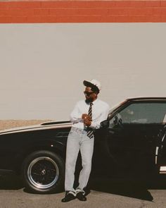 a man standing next to a black car