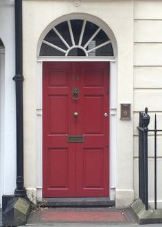 a red door is in front of a white building