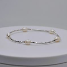 This bracelet consists of a string of tiny sterling silver plated brass seed beads and a large ivory freshwater pearl feature in the center. The bracelet is made on an adjustable cord for a comfortable fit around your wrist. An accessory you can wear with formal or casual apparel   Made very sturdy and adjustable to fit all wrist sizes. Silver Beaded Bracelet, Silver Bead Bracelet, Silver Beads, Beaded Bracelet, Favorite Jewelry, Fresh Water, Freshwater Pearls, Seed Beads, Silver Plated