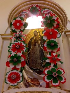 an image of the virgin mary surrounded by poinsettis and flowers in a church