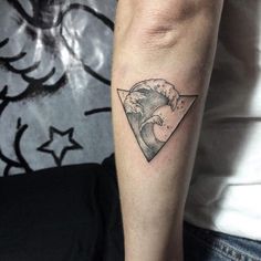 a man's arm with a wave and triangle tattoo on the left inner forearm