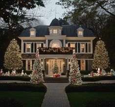 a large house decorated with christmas lights and trees