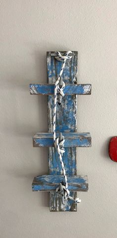 a piece of wood that has been painted blue and is tied up to a wall