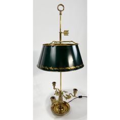 a table lamp with a green shade and gold trimmings on the bottom part