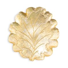 a gold leaf shaped dish on a white background