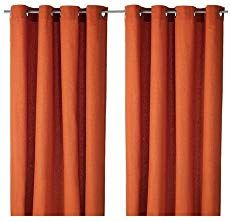 two orange curtains hanging on the side of a white wall and one is closed up