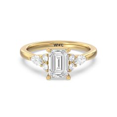 a rose gold ring with an emerald cut diamond in the center and three diamonds on each side