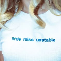 a close up of a person wearing a white shirt with the words little miss unstable on it