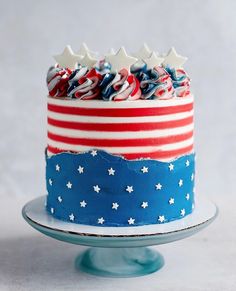 a red, white and blue cake with stars on top is sitting on a plate