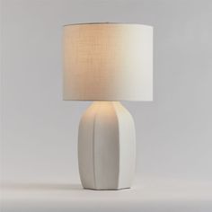 a white table lamp with a beige shade