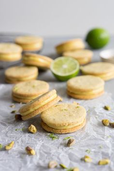 lemon lime shortbread cookies with pistachios on parchment paper next to them