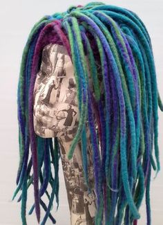 a mannequin head with multi colored dreadlocks on it's head