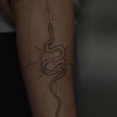 a woman's arm with a snake tattoo on it and a candle in the middle