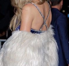 the back of a woman's dress with white fur