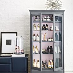 a cabinet that has some shoes on top of it and a framed picture next to it