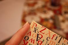 a person holding up a piece of paper with letters on it