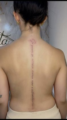 the back of a woman's upper body with writing on her left shoulder and chest