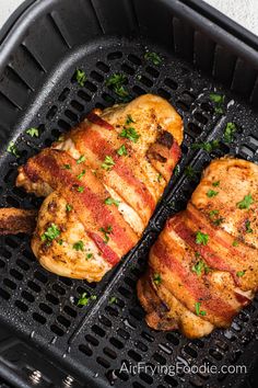 two pieces of chicken sitting on top of a grill