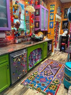 a brightly colored kitchen with lots of magnets on the counters and rug in front