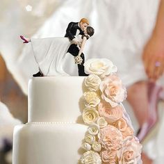 a bride and groom kissing on top of a wedding cake