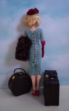 a doll is standing next to two suitcases