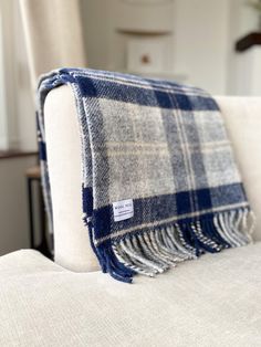 a blue and white plaid blanket sitting on top of a couch