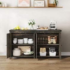 an open shelf with food and drinks on it in front of a wall mounted art piece