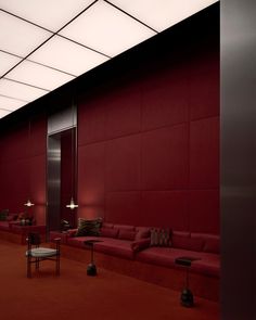 an empty room with red couches and lamps