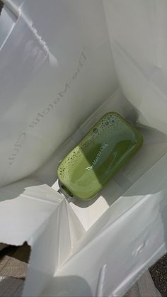 a green container sitting inside of a white bag