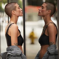 two women with shaved hair are facing each other