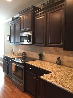 a kitchen with dark wood cabinets and granite counter tops