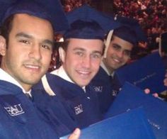 three men in graduation caps and gowns posing for the camera