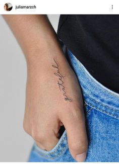 a woman's hand with a small tattoo on her left wrist and the word love is