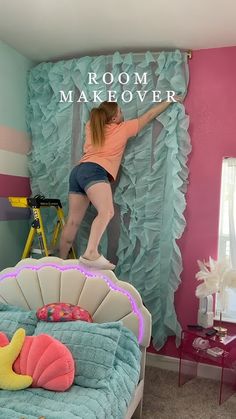 a woman standing on top of a bed next to a pink and blue wall with the words room makeover