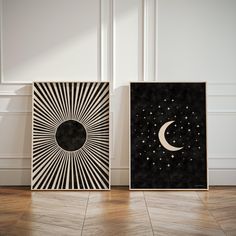 two black and white art prints with the moon and stars on them in front of a wall