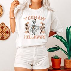 "Super cute vintage-inspired yeehaw hellnaw tee design on the premium, luxurious Comfort Colors® 1717 t-shirt you will not want to take off. Sure to bring cheerful vibes to you and your friends. ✅ Super Comfy 100% Ring-Spun Cotton T-Shirt That Feels \"Broken in\" And Soft For Your Skin ✅ Garment Is Made With The Most Expensive Dyeing Process, Reducing Shrinking Up To 99% ✅ Relaxed, Unisex Fit Will Be Great For Women And Men (To Get That T-Shirt Dress Effect, Size Up 2 Sizes) ✅ Will Last You For White Western Style T-shirt For Fall, White Graphic Print T-shirt For Western-themed Events, White Graphic Tee For Western-themed Events, Country Style White Graphic T-shirt, Pre-shrunk T-shirt For Western-themed Summer Events, Casual White T-shirt For Western-themed Events, White Letter Print T-shirt For Ranch, Retro Summer T-shirt For Western-themed Events, Retro T-shirt For Western-themed Summer Events