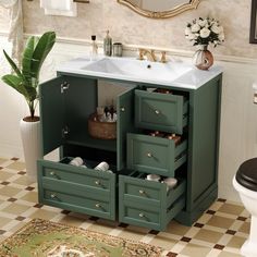 a bathroom with a sink, mirror and green cabinetry in it's corner