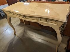 an antique desk is being worked on in a shop with other furniture and accessories around it