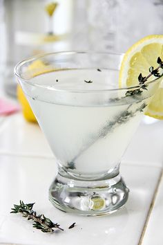 a martini glass filled with white liquid and garnished with lavender