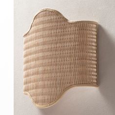 a wall mounted wicker basket on the side of a white wall