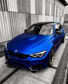 a blue bmw car parked in front of a building