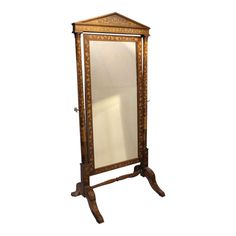 an ornate wooden mirror on stand against a white background