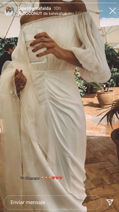 a woman in a white dress holding an umbrella