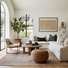 a living room filled with furniture and large windows