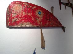 a red fish shaped object hanging from the side of a wall next to other items